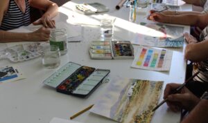 Alumnos pintando con acuarelas y pinturas en Escuela de Arte